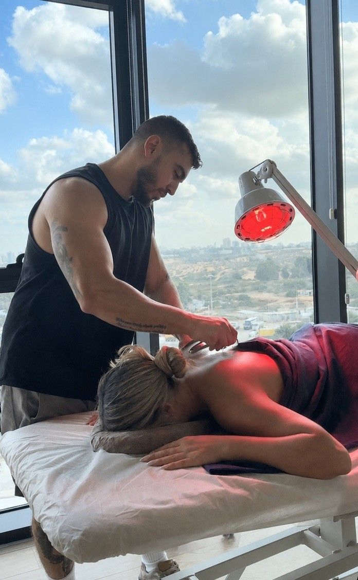 אדיר אשר מטפל במטופלת בקליניקת Recovery Center בחולון, ליד חלון בקומה 8